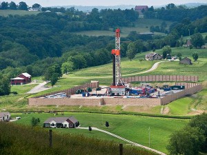 A natural gas derrick rises from the countryside near family homes in North Dakota.