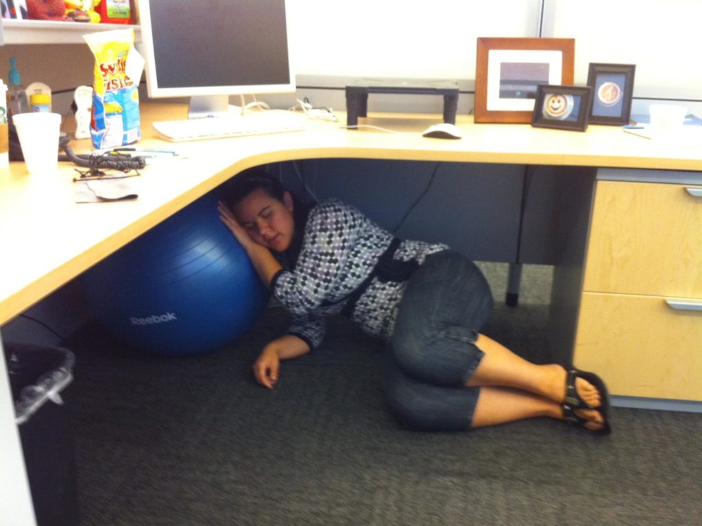 woman sleeping under her desk at work