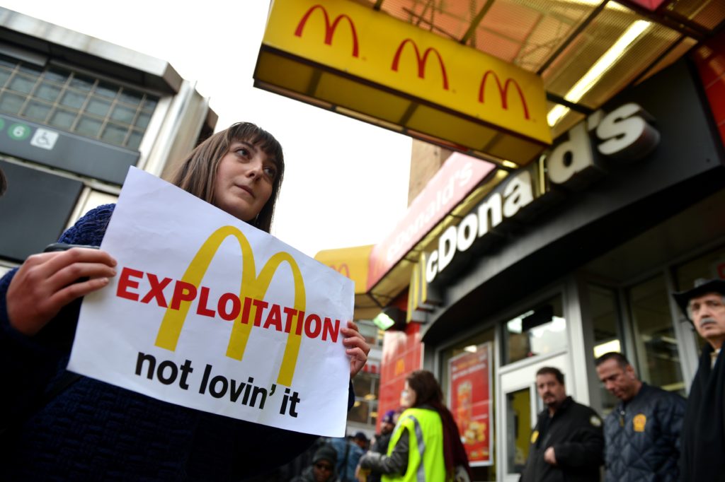 mcdonalds protestor with a sign about exploitation