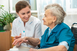 nursing home worker helping an elderly woman in a wheelchair