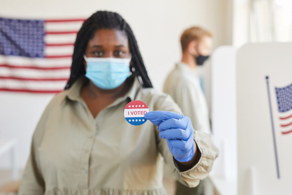 woman showing sticker she got for voting in Washington state