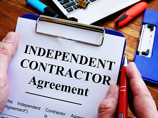independent contractor agreement on a clipboard