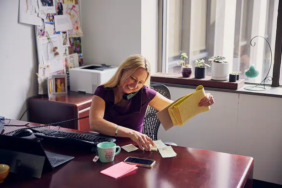 Karolina working in an office while talking on a phone.