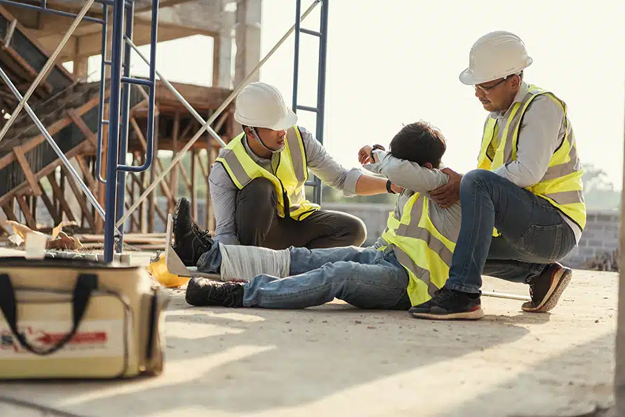 two coworkers helping the victime of a construction work injury