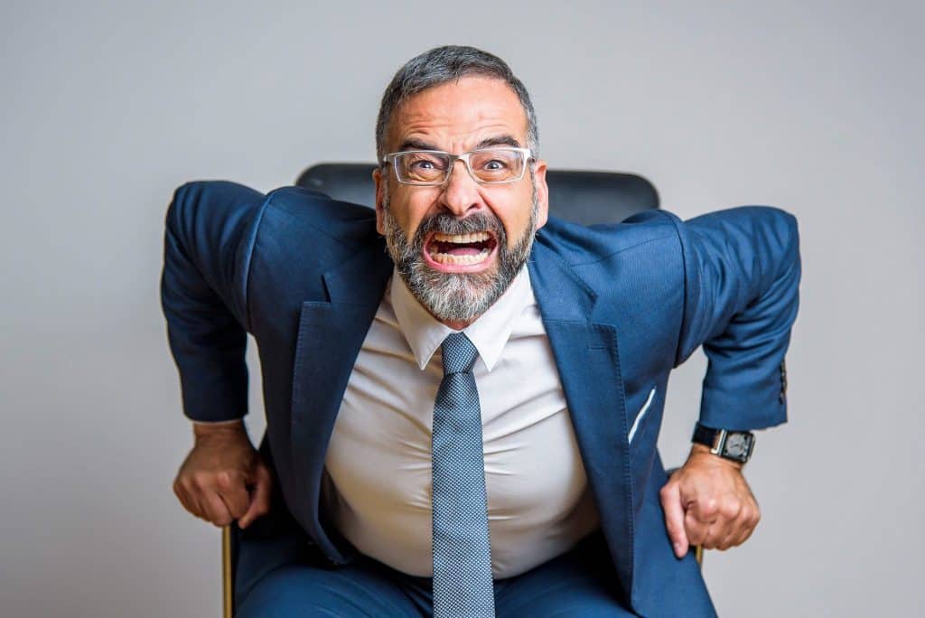 an abusive boss yelling into the camera