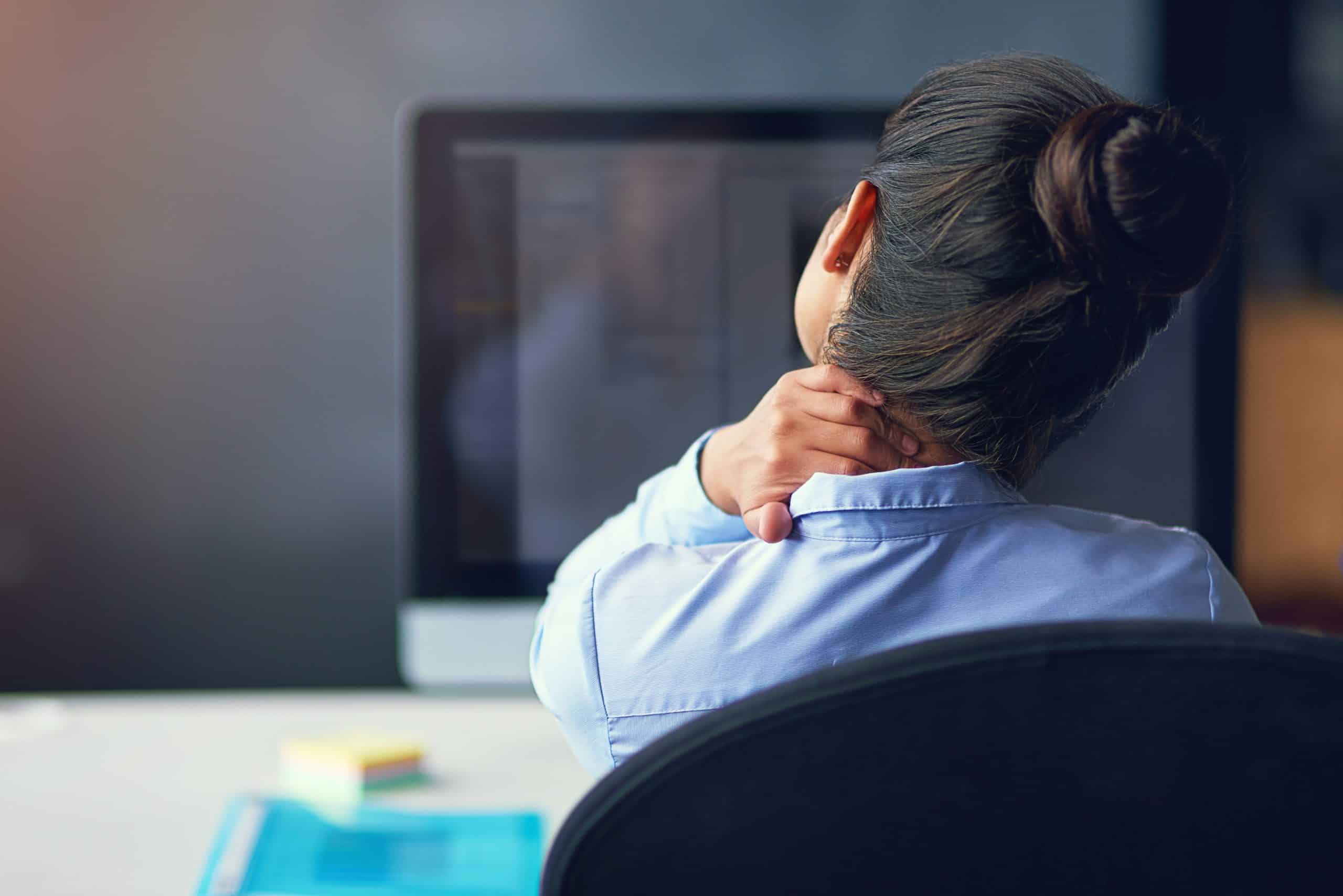Rearview shot of a businesswoman suffering from neck pain at the office_musculoskeletal disorder iStock-501672764_credit_ peopleimages