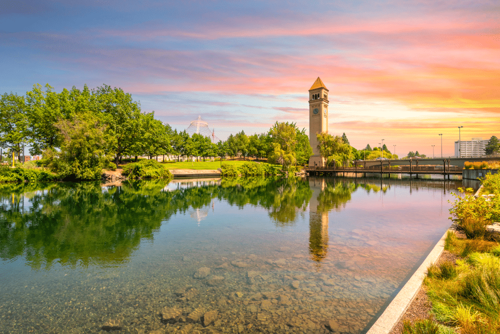 The Spokane Clock Tower and Pavilion along the river in Riverfront Park, downtown Washington, under a colorful sunset in Spokane, Washington, USA