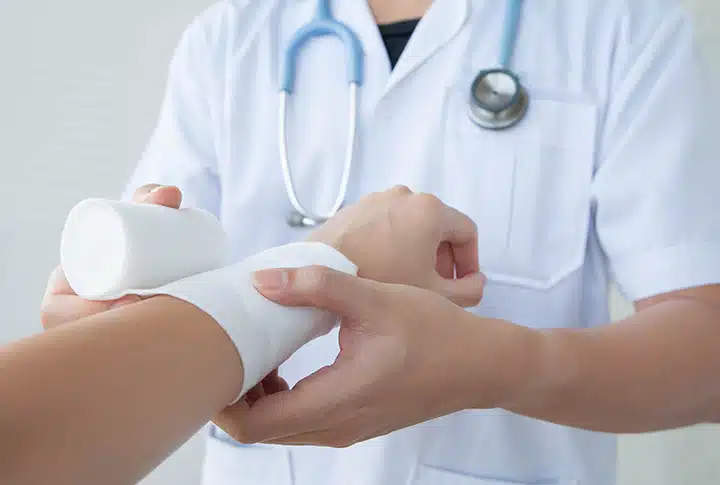 burn injury in the workplace being wrapped and treated by a doctor
