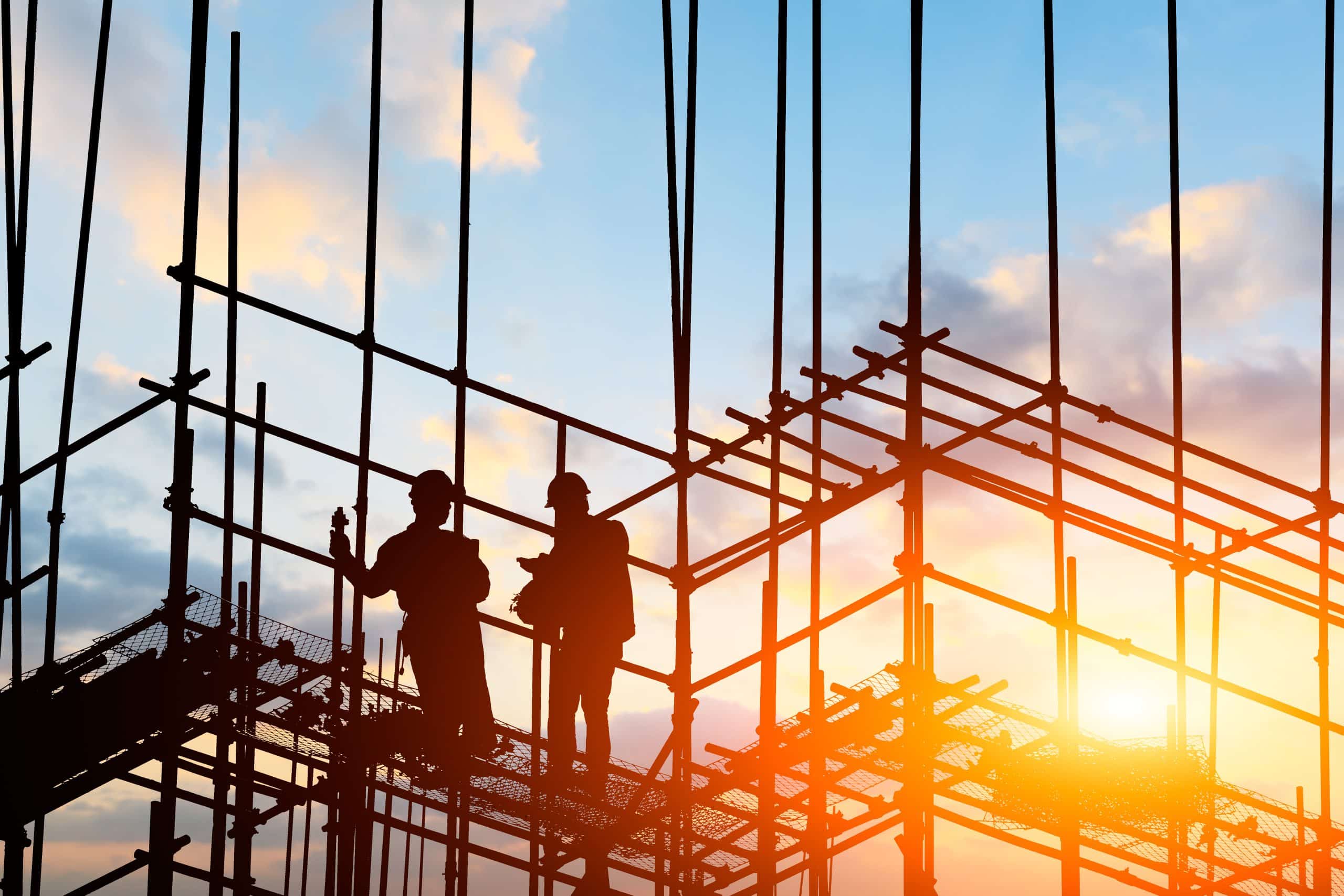 workers' compensation construction worker on construction site at sunset
