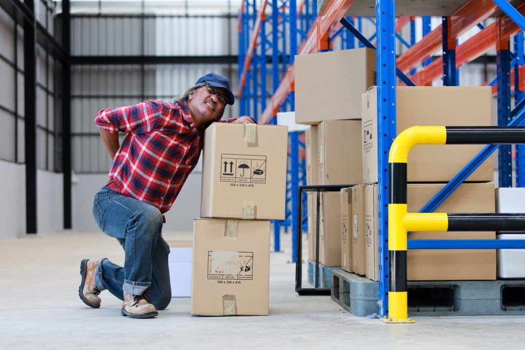 worker hurt his back lifting a heavy box in a warehouse