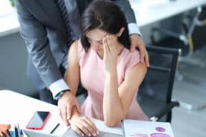 Businessman pestering female colleague in the workplace. Harassment at work concept