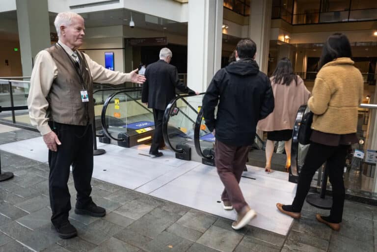 worker ushering clientele at a theater