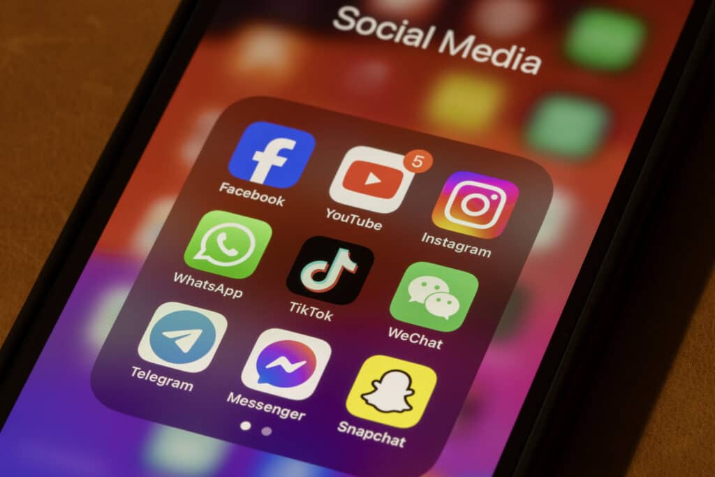 Some of the most popular social media apps by number of monthly active users, including Facebook, YouTube, Instagram, WhatsApp, TikTok, WeChat, Telegram, Messenger, and Snapchat, are seen on an iPhone.