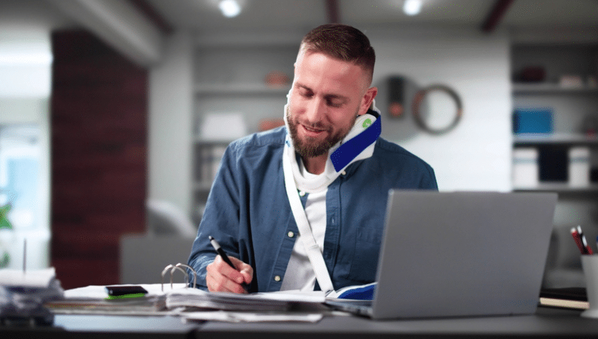 Injured worker looking at the camera, with an HR administrator sitting at desk nearby
