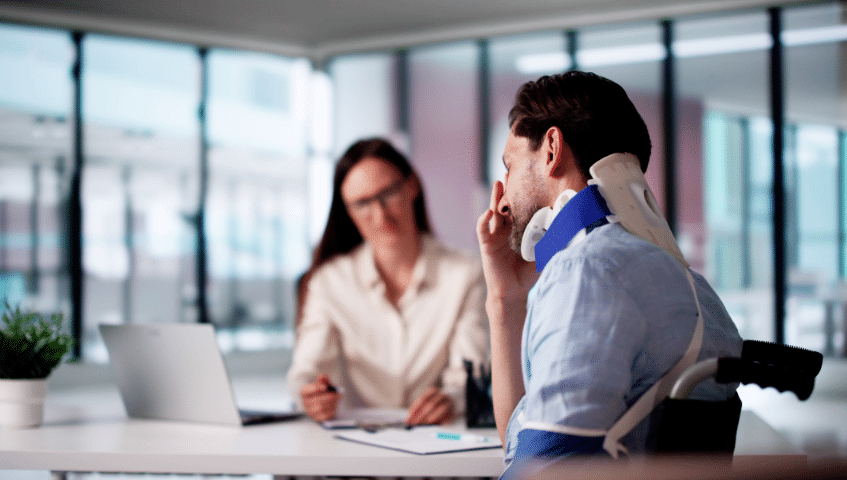 Injured worker speaking with a woman at a desk