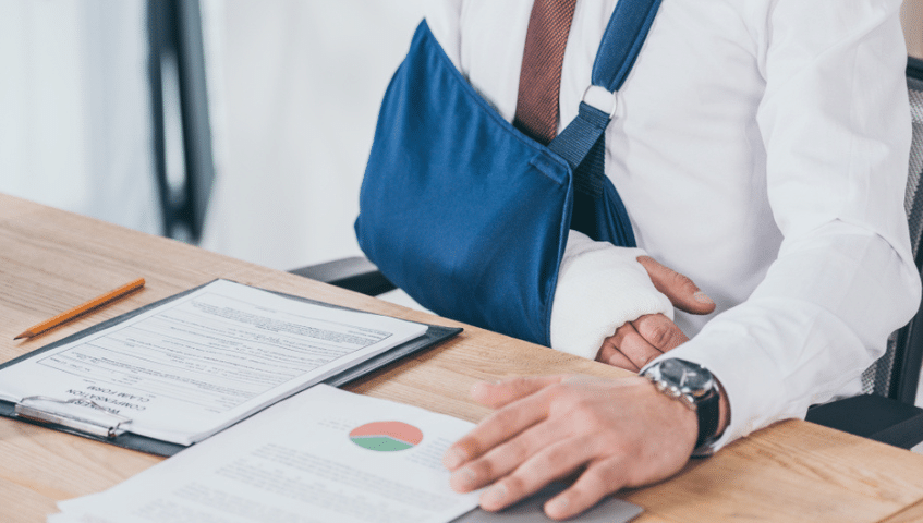 Man in a sling looking over paperwork
