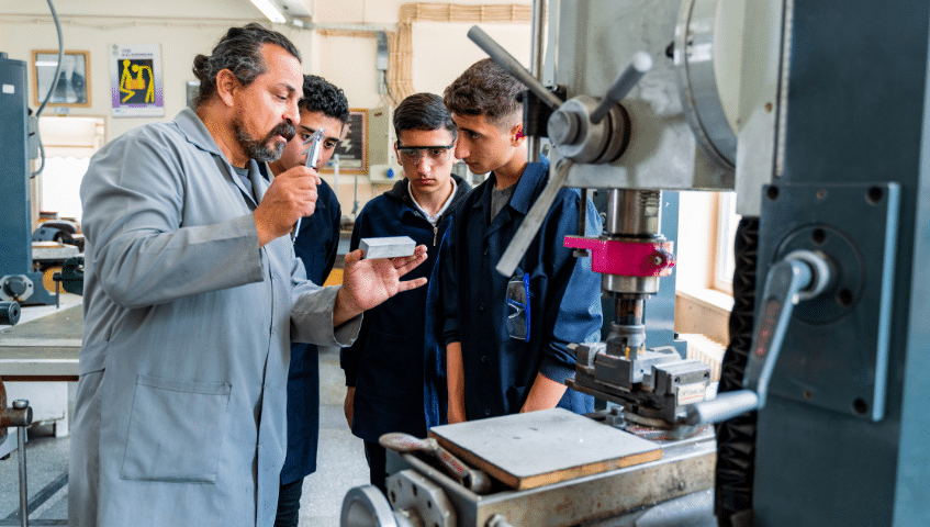 A mentor explains a piece of equipment to students.