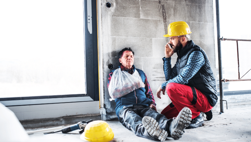 Injured construction worker sitting at a desk looking at paperwork