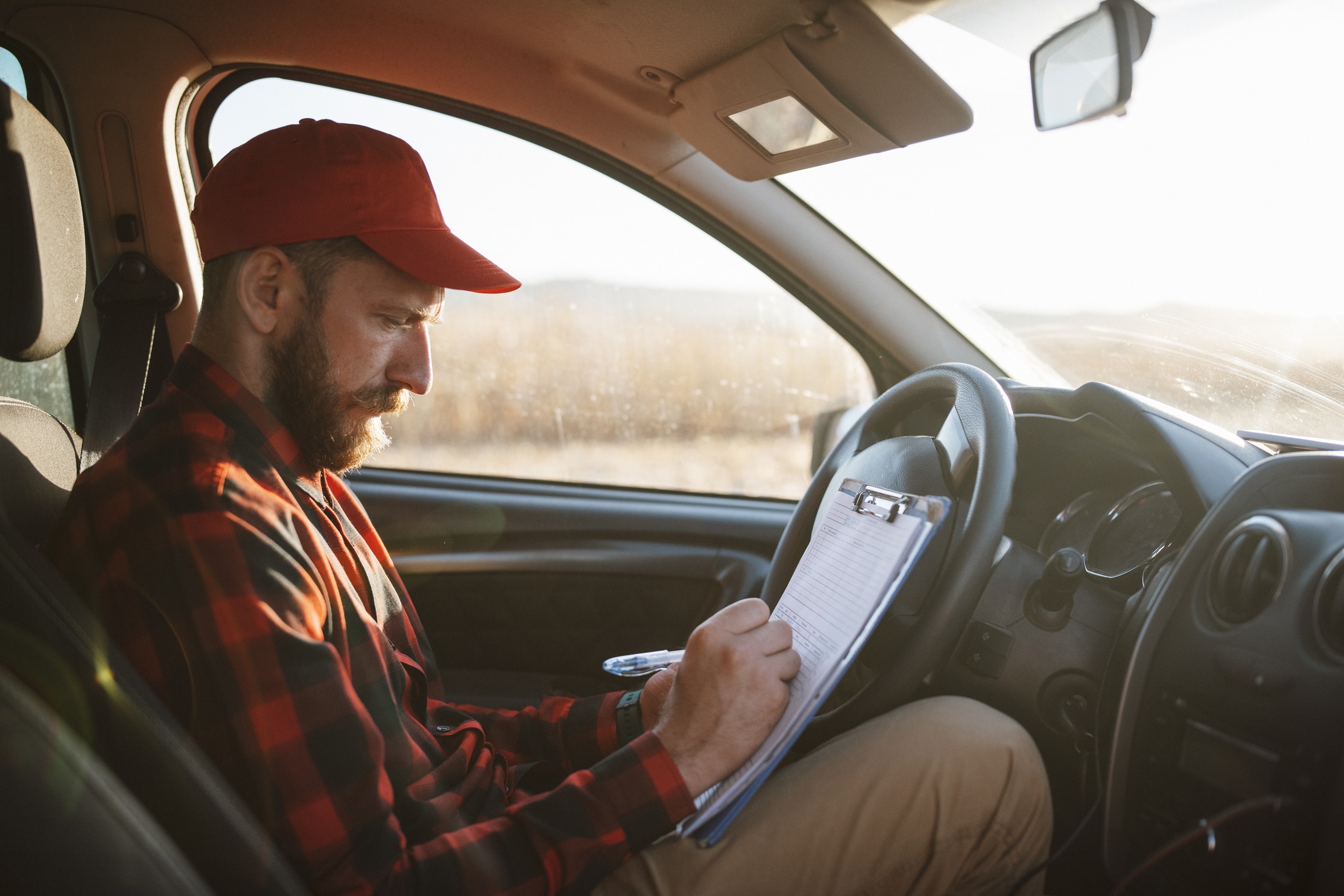 Driver in his vehicle calculating his mileage for reimbursement